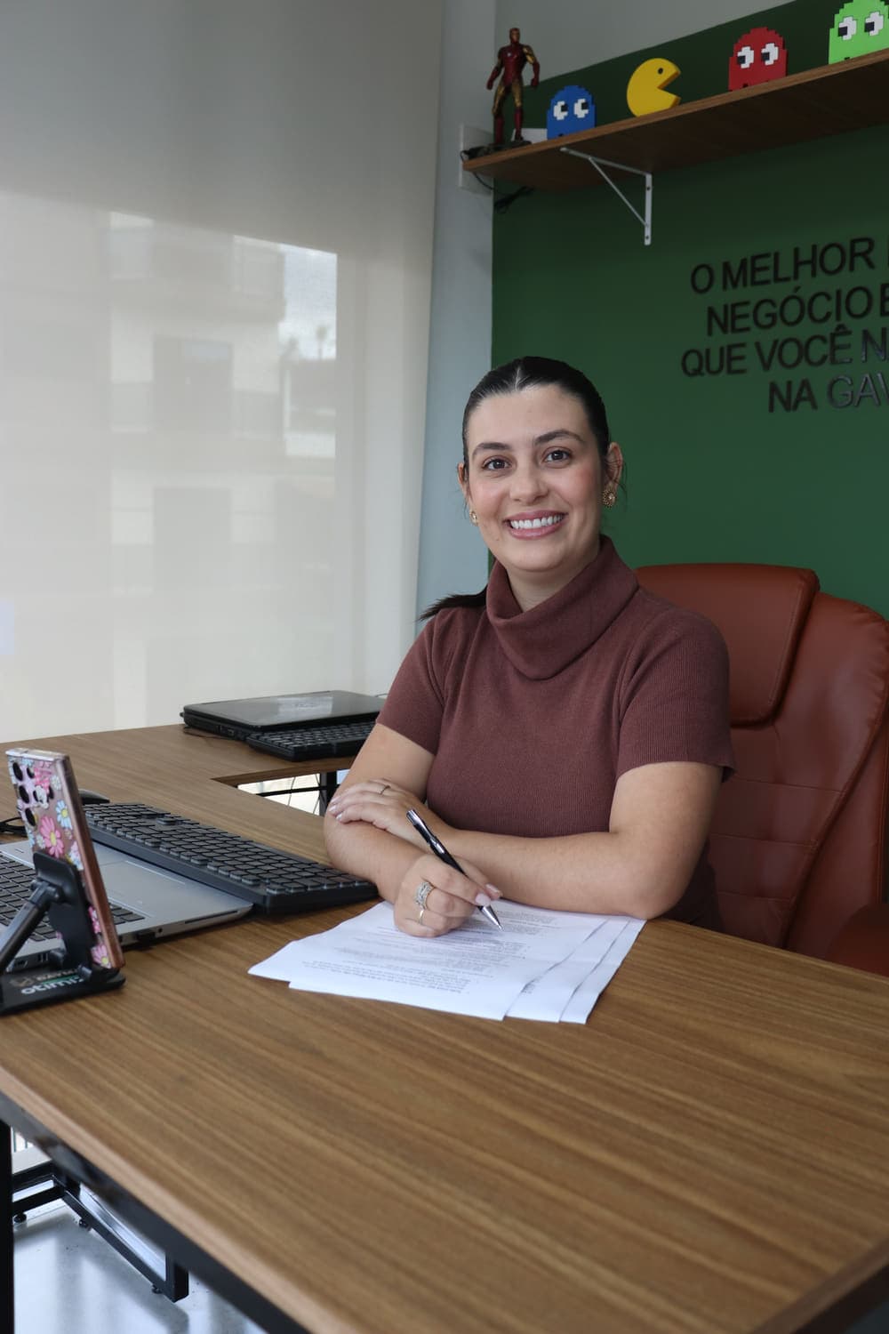 Contadora da Daymar sorrindo em sua mesa durante o atendimento a um cliente